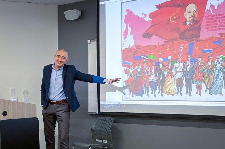 Azamat Junisbai points to a Soviet painting during a fall 2024 presentation